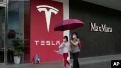 資料照：行人走過北京的特斯拉專賣店。 （2023年5月31日）