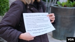 反對香港財經事務及庫務局局長許正宇訪問倫敦的示威者手持抗議標語 （美國之音/鄭樂捷）