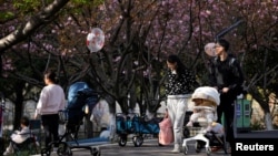上海一個公園父母推著嬰兒車賞春。（2023年4月2日）