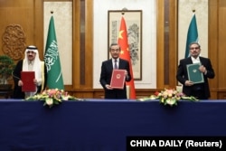 中共中央外辦主任王毅與伊朗最高國家安全委員會秘書阿里·沙姆哈尼（右）同沙特國務大臣、內閣成員和國家安全顧問穆薩伊德·本·穆罕默德·艾班在北京舉行會談。（2023年3月10日）