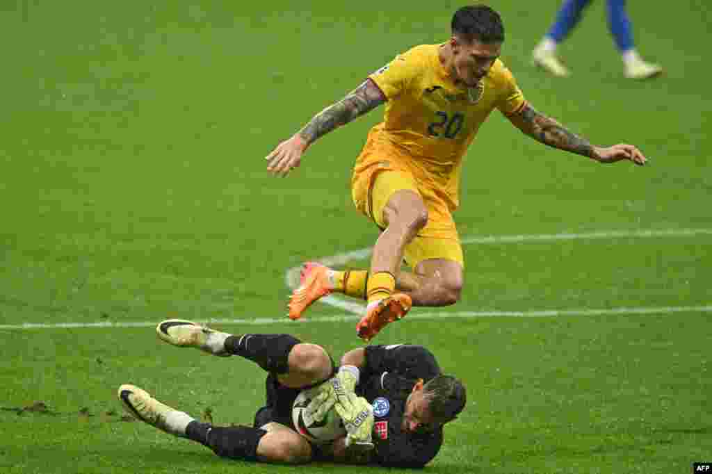 Slovakia&#39;s goalkeeper #01 Martin Dubravka saves at the feet of Romania&#39;s forward #20 Dennis Man during the UEFA Euro 2024 Group E football match between Slovakia and Romania at the Frankfurt Arena in Frankfurt, Germany.