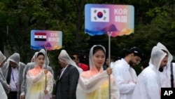 ອາ​ສາ​ສະ​ໝັກ​ຖື​ປ້າຍ​ໃນ​ລະ​ຫວ່າງ​ພິ​ທີ​ຕ້ອນ​ຮັບ​ທີ​ນັກ​ກິ​ລາ​ຢູ່​ງານ​ແຂ່ງ​ຂັນ​ກິ​ລາ ເອ​ຊຽນ ເກມ ຄັ້ງ​ທີ 19 ໃນ​ເມືອງ ຫາງ​ໂຈ, ຈີນ, 21 ກັນ​ຍາ 2023.