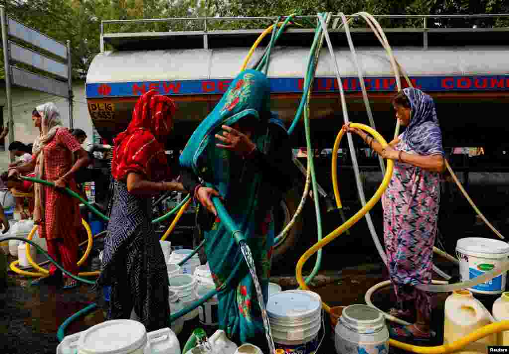 Residents fill their containers with drinking water from a water tanker during a hot day in New Delhi, India.