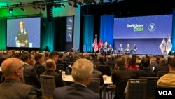 台灣海軍司令唐華上將(第二排左2）與台灣駐美軍事代表團團長魏中興(第二排左1)參加美國海軍聯誼會“海空天”2024年會。螢幕上為美國海軍作戰部長麗莎弗朗切蒂上將。 (2024年4月8日，美國之音鍬辰芳拍攝)