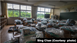 日本福島核災區的學生撤離課室時，學生留下書本與文具，未有時間執拾，老師把它們包好。Sing Chan感嘆，現實是恐怕同學們永遠也不能回來。 (圖片來源：被訪者提供)