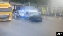 This screen grab taken from CCTV footage on May 15, 2024, shows a man exiting a stolen black Peugeot vehicle after ramming a prison van transporting an inmate during an attack which took place at a road toll in Incarville, northern France, May 14, 2024.