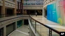 一名男子在北京一家空荡荡的商场里走路。(2023年7月27日)