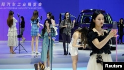 资料照：上海汽车展上销售人员在直播带货。（2022年4月19日）