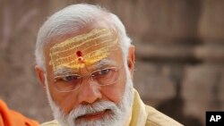 ແຟ້ມພາບ - ນາຍົກລັດຖະມົນຕີອິນເດຍ ທ່ານ ນາເຣນດາ ໂມດີ (Narendra Modi) ເອົາແປ້ງໄມ້ກິດສະໜາ ແລະ ສີແດງເລືອດນົກ ທາໜ້າຜາກຂອງທ່ານ ໃນລະຫວ່າງພິທີເປີດ Kashi Vishwanath Dham Corridor ເມືອງວາຣານາສີ (Varanasi) ປະເທດອິນເດຍ, ວັນທີ 13 ທັນວາ 2021. 