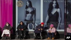 几位老者坐在北京一家维多利亚的秘密专卖店外晒太阳。（2023年7月22日）