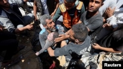 巴勒斯坦民众在加沙中部努塞拉特难民营的废墟下找到一具死亡儿童的尸体。（2024年5月14日）