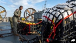 在美國海軍發布的這張圖片中，美國海軍人員2023年2月10日準備將在南卡羅來納州默特爾海灘（Myrtle Beach）海岸附近尋回的材料運往聯邦調查局，這些材料是從中國高空氣球被擊落後回收的。