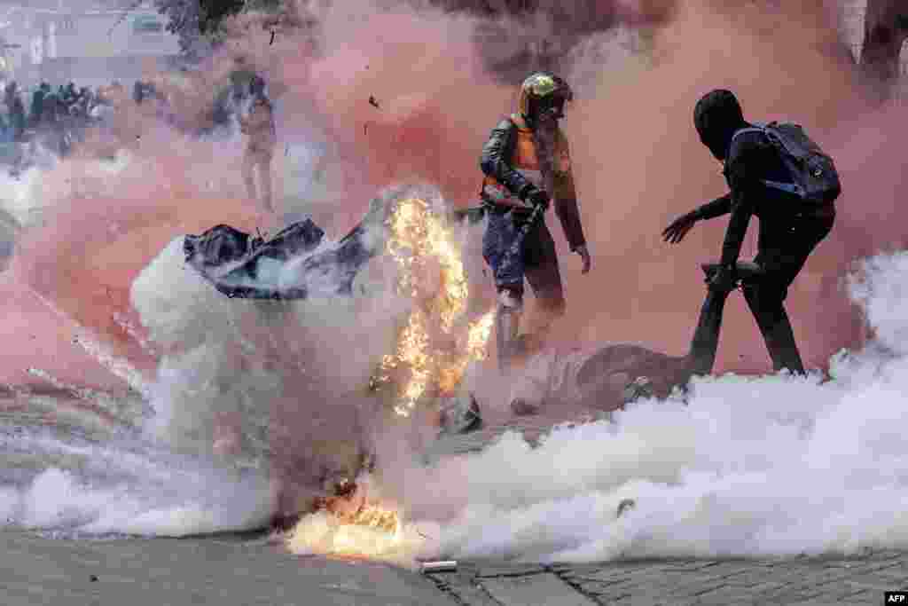A tear gas canister explodes as protesters try to help injured people outside the Kenya Parliament during a nationwide strike to protest against tax hikes and the 2024 finance bill, in downtown Nairobi.