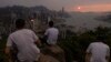 Mainland Chinese tourists look at sunset from a hill in Hong Kong, April 26, 2023.
