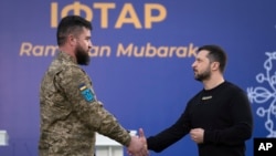 2023 年4月7日，在乌克兰基辅郊外的一个伊斯兰中心举行的庆祝伊斯兰斋月的开斋晚宴前，乌克兰总统泽连斯基（右）向一名穆斯林军人颁奖。