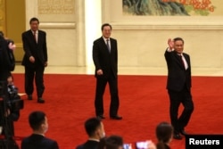 中國總理李強、副總理丁薛祥與何立峰抵達人大會堂出席記者會。（2023年3月13日）