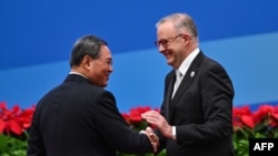 资料照：中国总理李强与澳大利亚总理阿尔巴尼斯在上海举办的第六届中国国际进口博览会开幕式上握手。（2023年11月5日）