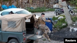 A Lebanese army soldier jumps off a military vehicle in Al Qulaylah in southern Lebanon, April 7, 2023. The army said on Saturday it had arrested a prominent al-Qaida leader in Deir Ammar town, northeast of the city of Tripoli.