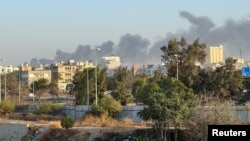 Smoke rises amid clashes between armed factions, in Tripoli, Libya, Aug. 15, 2023.
