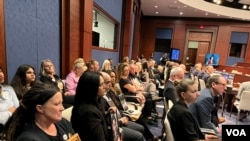 美国芬太尼危机受害者家属在国会众议院中共问题特设委员会针对芬太尼泛滥问题召开的听证会上手拿家人的照片聆听会议内容。（2024年4月16日，美国之音记者李逸华摄）
