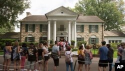 FILE - Fans wait outside Graceland, Aug. 15, 2017, in Memphis, Tenn. The granddaughter of Elvis is fighting plans to publicly auction his Graceland estate after a company tried to sell the property based on claims that a loan was not repaid.