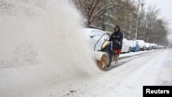 一名工人在北京街头扫雪。（2023年12月14日）