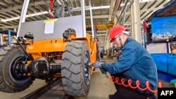 中國山東省青州市的一個鏟車工廠的工人在組裝鏟車。 （2023年10月18日）