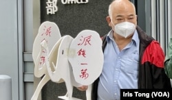 社民连成员曾健成手持自制的”大白象“道具，要求政府停止乱花公帑的”大白象工程”，全民派现金一万纾解民困 (美国之音记者/汤惠芸)