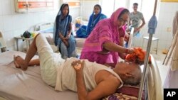 一名婦女在印度北方邦的一所醫院裡用濕布擦拭她生病的兄弟的頭部，讓他在熱浪中保持涼爽。(2023年6月19日)