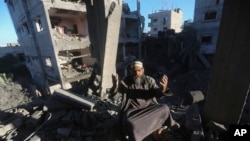 2023年12月15日，一名巴勒斯坦人在以色列襲擊加沙走廊拉法的住宅大樓後作出反應。 （美聯社照片）