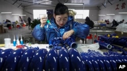 中國河北武強縣的一名樂器廠工人在生產線上。（2023年2月23日）