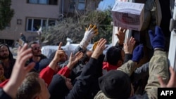 土耳其哈塔伊省地震災區的民眾在領取救災物品。(2023年2月16日)