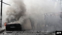 以色列袭击黎巴嫩南部城市西顿后，黎巴嫩消防队员在扑灭一辆汽车的大火。（2024年8月21日）