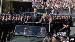 2023年8月15日，波蘭總統杜達在抵達波蘭華沙參加大規模閱兵式時向部隊致意。（美聯社照片）