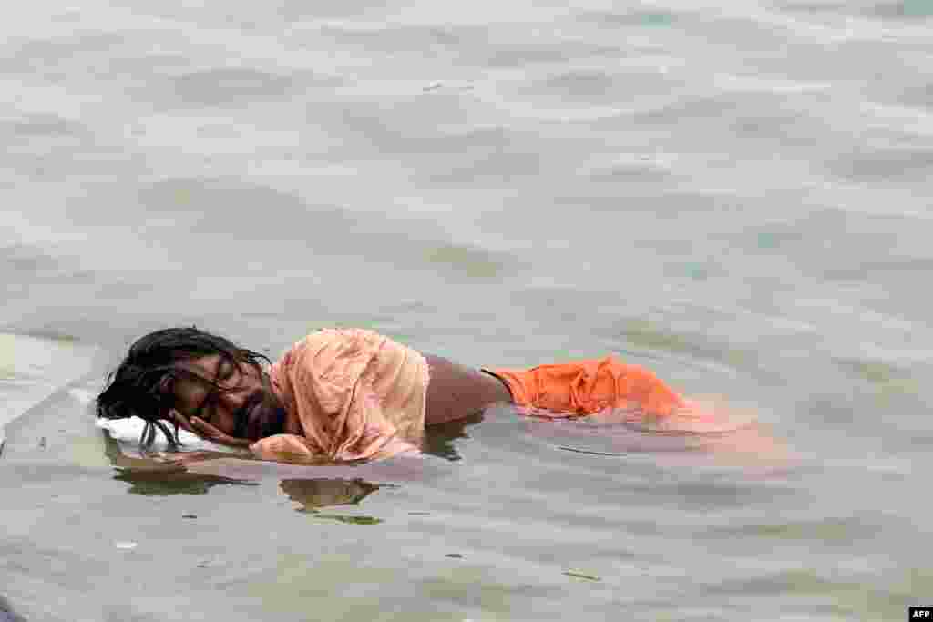 A man sleeps in the river Ganges on a hot summer day in Varanasi, India.