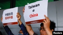 支持台灣獨立的人士在台北桃園國際機場舉牌抗議台灣前總統馬英九前往中國大陸的旅行。 (2023年4月7日)