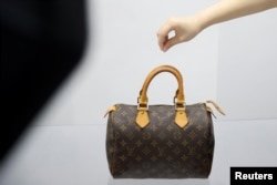 资料照：北京的一家二手奢侈品商店的职员在布置展品。（2020年10月10日）