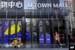 一名清洁工人正在北京一家购物中心前打扫卫生。（2023年4月18日）