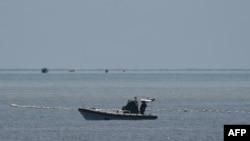 中国海警人员在南海争议海域乘坐充气船守在通往中国控制的黄岩岛的通道上。(2023年9月22日)