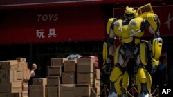 北京一名工人在运送将出口英国著名汉姆利玩具店的大黄蜂玩具。(2023年7月25日)