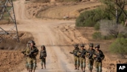 资料照片：以色列军人在以色列南部的加沙边境地区行进。(6月13日)