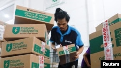 An employee packs goods at Goto's e-commerce unit Tokopedia's warehouse in Jakarta, Indonesia, August 31, 2022. REUTERS/Ajeng Dinar Ulfiana