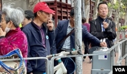 中国大陆旅客在土瓜湾一间酒楼吃完午饭后，聚集在行人路边抽烟 (美国之音/汤惠芸)