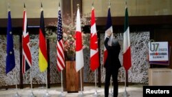 一名男子在日本東京舉行七國集團外交部長會議期間整理成員的旗幟。 （2023年11月8日）