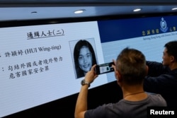 香港当局在记者会上公布被通缉的五名活动人士之一许颖婷的照片。（2023年12月14日）