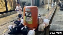 香港政府4月1日開始在14個處所實施垃圾徵費”先行先試”計劃，包括深水埗北河街的舊式住宅大廈，附近街上的垃圾桶爆滿，旁邊放置了不少疑似家居垃圾。