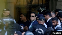 2023年5月12日，安全人員在巴基斯坦伊斯蘭堡護送前總理伊姆蘭·汗（中）在伊斯蘭堡高等法院出庭。（路透社照片）