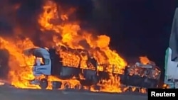 ​ຄວັນ​ກຳ​ລັງ​ພຸ່ງ​ຂຶ້ນ ຂະ​ນະ​ທີ່​ໄຟ​ໄໝ້​ລົດ​ບັນ​ທຸກ ໃກ້​ຊາຍ​ແດນ​ມຽນ​ມາ ກັບ​ຈີນ ຢູ່​ເຂດ​ເມືອງ​ມູ​ເຊ ໃນ​ຮູບ​ພາບ​ຈາກ​​ວີ​ດີ​ໂອ ທີ່​ລົງ​ໃນສື່​ສັງ​ຄົມ ເມື່ອ​ວັນ​ທີ 23 ພະ​ຈ​ິກ 2023. 