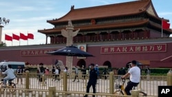 資料照片：北京天安門前一名安全人員在監視過往居民。 （2023年6月4日）