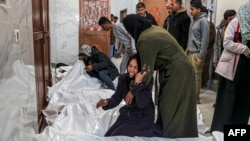 2024年3月5 日，在加沙地带南部汗尤尼斯的欧洲医院太平间，巴勒斯坦人在以色列轰炸中丧生的亲属尸体旁边哀悼。（法新社照片）